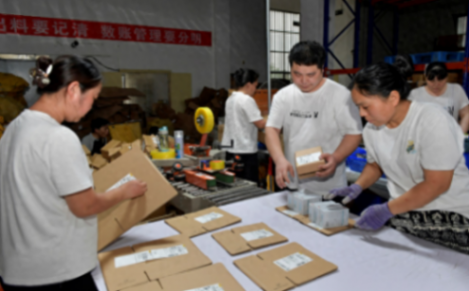 拼多多店铺快递日单量近3000件，多位工人一起贴快递面单仍应接不暇。周甬摄